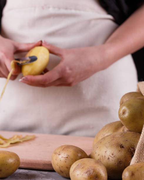 istock A young woman in an apron peeling potatoes 1144575379