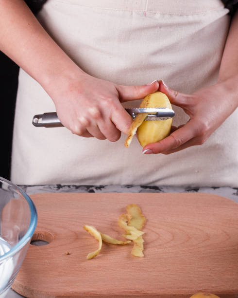 istock A young woman in an apron peeling potatoes 1144575437