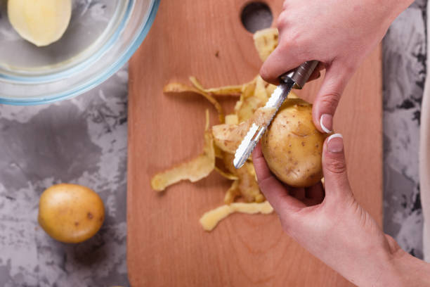 istock A young woman in an apron peeling potatoes 1144575451