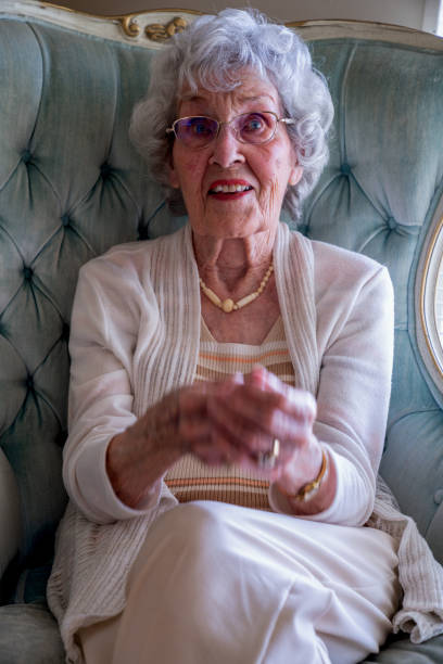 istock 100-Year Old Woman Having a Cheerful Conversation in Her Home 1144575465