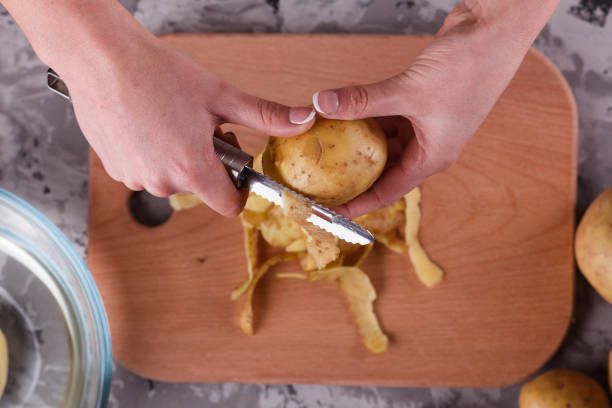 istock A young woman in an apron peeling potatoes 1144575511