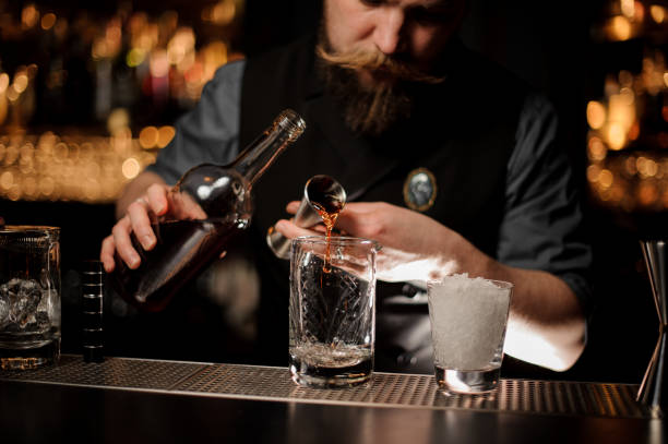 istock Bartender pouring an alcohol to the cocktail from the steel jigger 1144575729