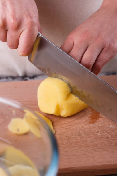 istock young woman in an apron cuts potatoes 1144575788