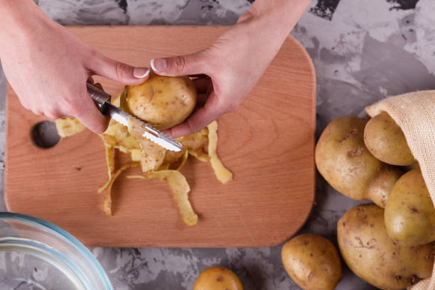 istock A young woman in an apron peeling potatoes 1144575911