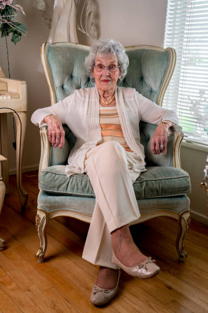 istock 100-Year Old Woman Having a Cheerful Conversation in Her Home 1144576154