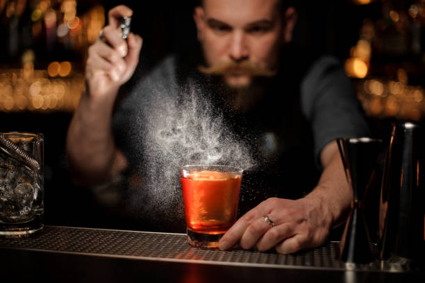 istock Bartender spraying to the cocktail glass with one big ice cube 1144576325