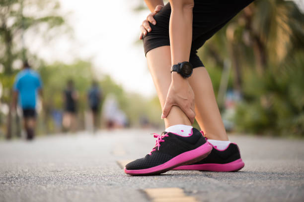 donna che soffre di un infortunio alla caviglia durante l'allenamento. concetto di infortunio sportivo in esecuzione. - twisted ankle immagine foto e immagini stock