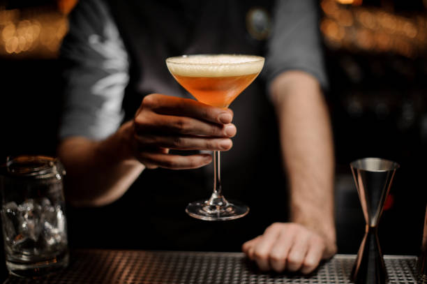 istock Male bartender serving cocktail with a whipped cream and grated nutmeg 1144577729