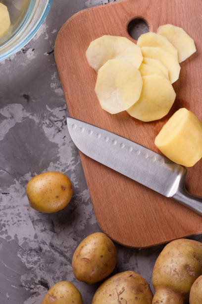 istock young woman in an apron cuts potatoes 1144578086