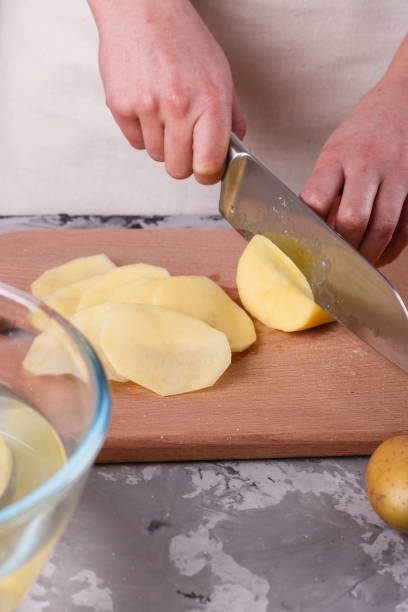 istock young woman in an apron cuts potatoes 1144578103