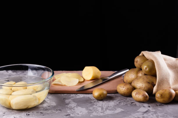 istock young woman in an apron cuts potatoes 1144578106