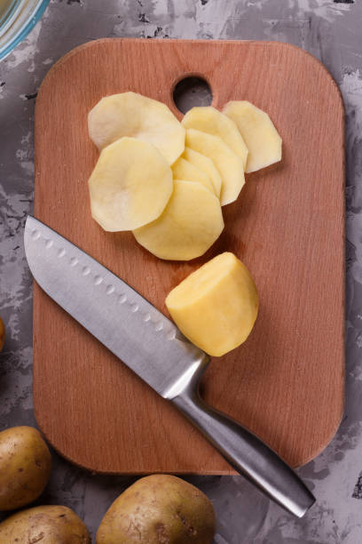istock young woman in an apron cuts potatoes 1144578817