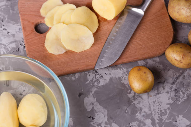 istock young woman in an apron cuts potatoes 1144578855