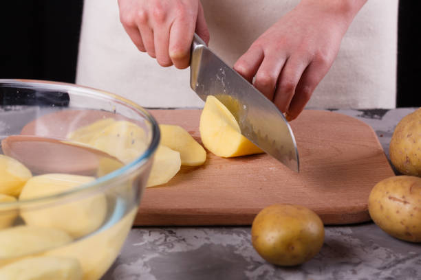 istock young woman in an apron cuts potatoes 1144578871