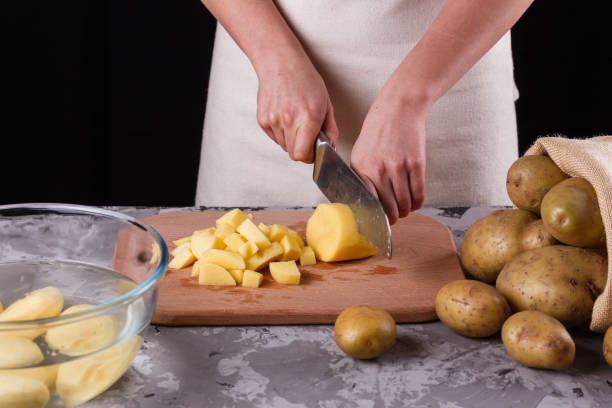 istock young woman in an apron cuts potatoes 1144578887