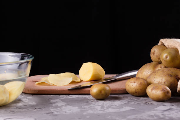 istock young woman in an apron cuts potatoes 1144579049