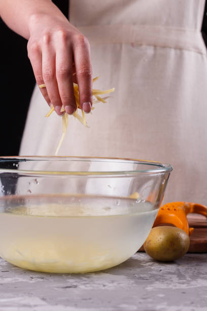 istock young woman in an apron cuts potatoes 1144579267