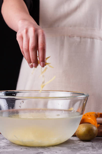istock young woman in an apron cuts potatoes 1144579427