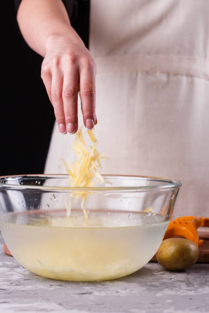 istock young woman in an apron cuts potatoes 1144579459