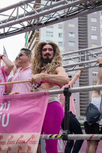 バレンシア、スペイン-6 月16日、2018: ゲイプライドデーのパレードの間にフロートの女性のような服を着たひげを生やした男 - group sex ストックフォトと画像