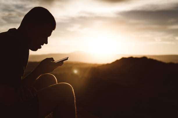 istock Man using smartphone during sunset at Moon Valley in Atacama desert 1144584891