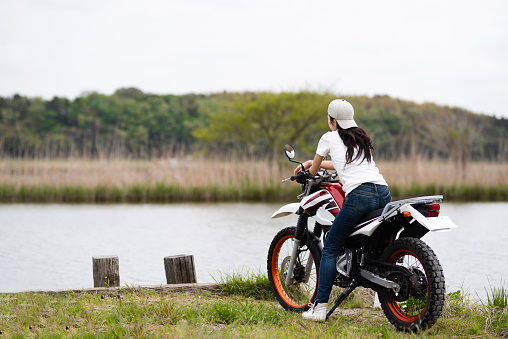 Woman parked a motorcycle by the lake