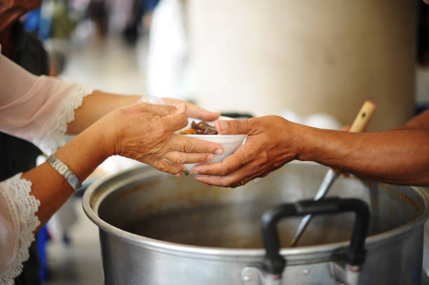 volunteers provide food for beggars : concepts feeding and help : the hands of the rich give food to the hands of the poor - centro de acolhimento para os sem abrigo imagens e fotografias de stock