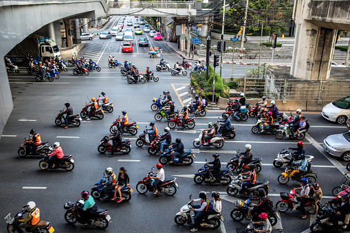 Motorbike traffic in Bangkok - Thailand.\n\nNote for inspectors: cars are heavily edited