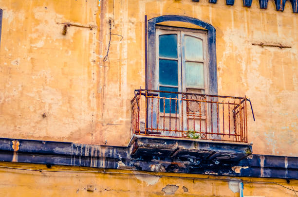 vintage balcony on an old abandoned and decaying house facade in italy - stone textured italian culture textured effect imagens e fotografias de stock
