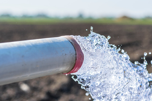 agua dulce que se desprende del tubo de agua de alta presión diesel de la tierra b bien en los campos agrícolas photo