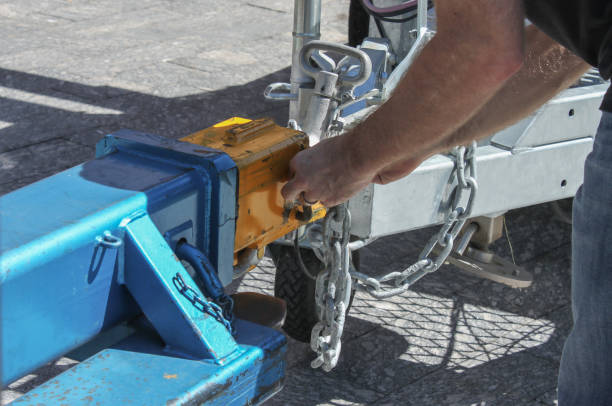 Man fastening a chain onto an industrial hitch on a trailer - close-up Man fastening a chain onto an industrial hitch on a trailer - close-up hitchhiking stock pictures, royalty-free photos & images
