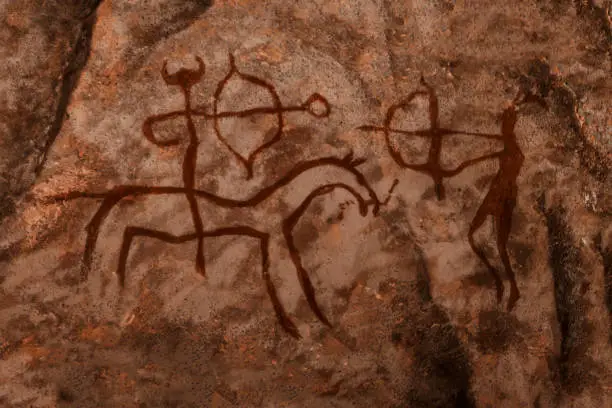 Photo of iDrawing of ancient hunters on the wall of the cave.