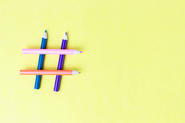 istock Hashtag sign from pencils on yellow background close-up, copy space 1144597892