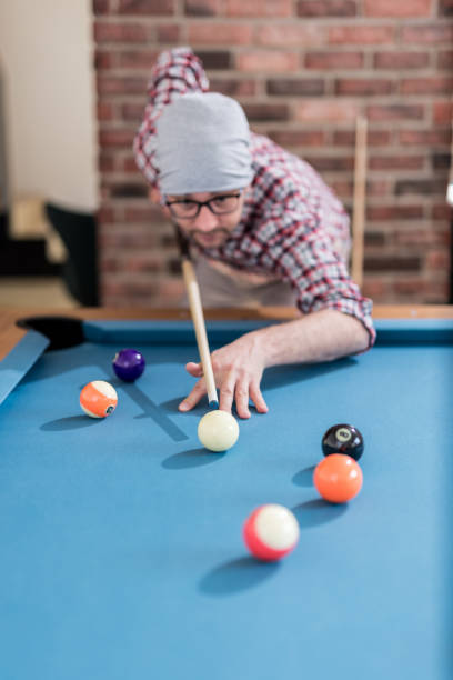 istock Fashionable urban man playing pool table billiards game. 1144600680