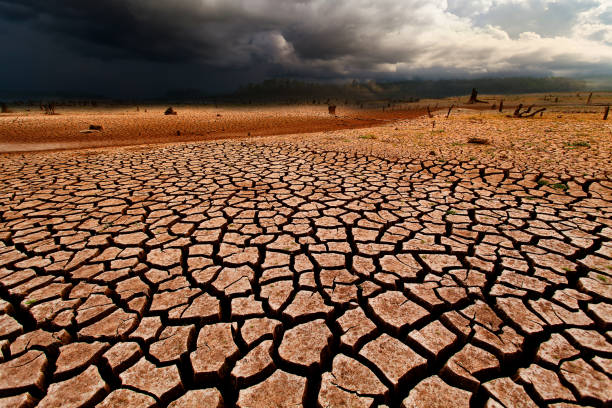 istock thunder storm sky Rain clouds Cracked dry land without wate 1144602289