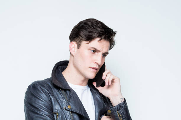 istock Close up view of attractive man wearing leather jacket and is using a smart phone 1144602704