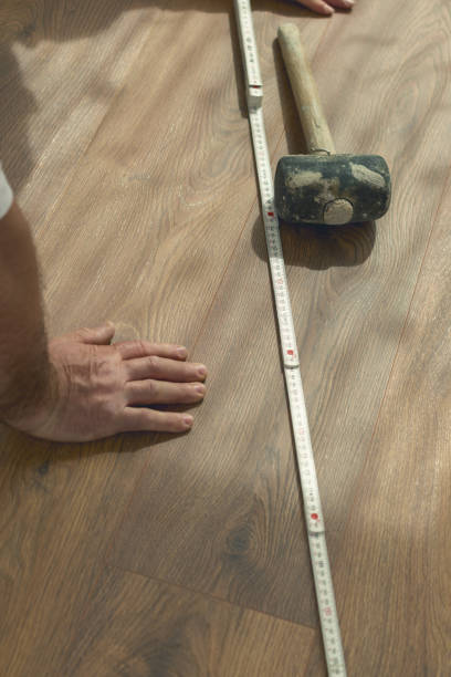 istock hand on freshly installed laminate floor next to rubber hammer and ruler 1144604146