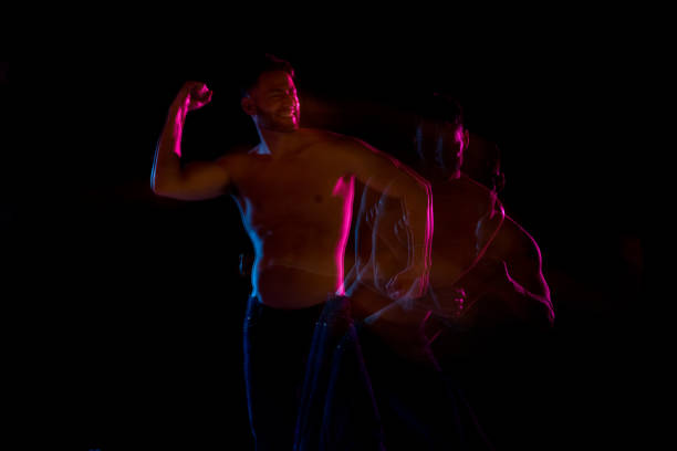 istock Shirtless man dancing with color gel lights 1144604361