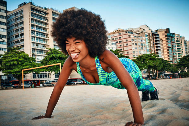 junge frau macht push-ups am strand - athlete push ups muscular build female stock-fotos und bilder