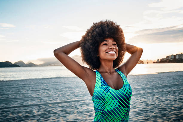 istock smiling fit young woman stretching on the beach 1144606673