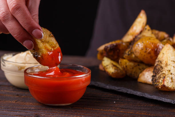 istock young woman dip fried potatoes to tomato sauce 1144606828