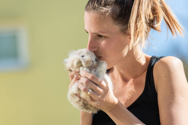 istock Young woman kissing her pet bunny 1144608149