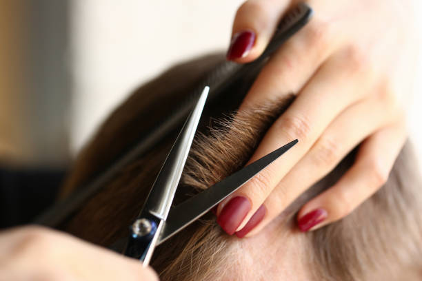 donna mano tenere i capelli forbici parrucchiere - tagliare i capelli foto e immagini stock