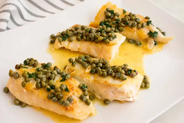 Fillets of fish topped with lemon-caper butter sauce