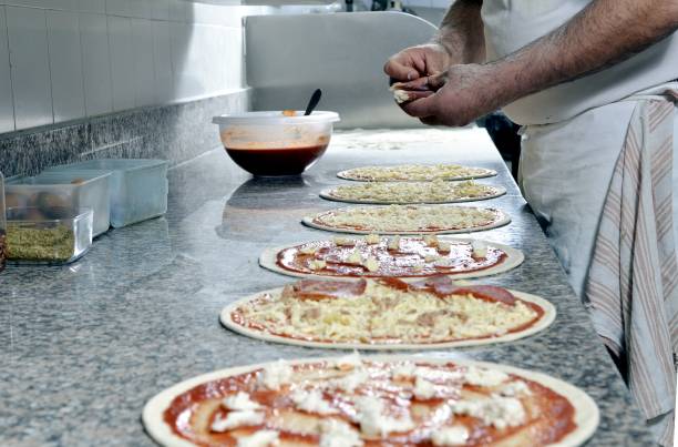 istock Close up of different Pizzas being made by chef in a Kitchen 1144611009
