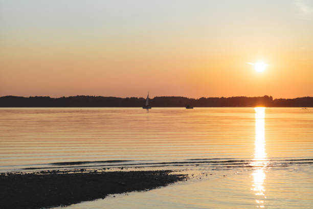 istock Amazing sunset in chiemsee lake with a sailboat navigating 1144612783