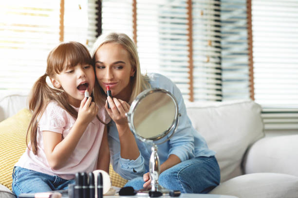 istock Mother and Daughter applying lipsticks. 1144614832