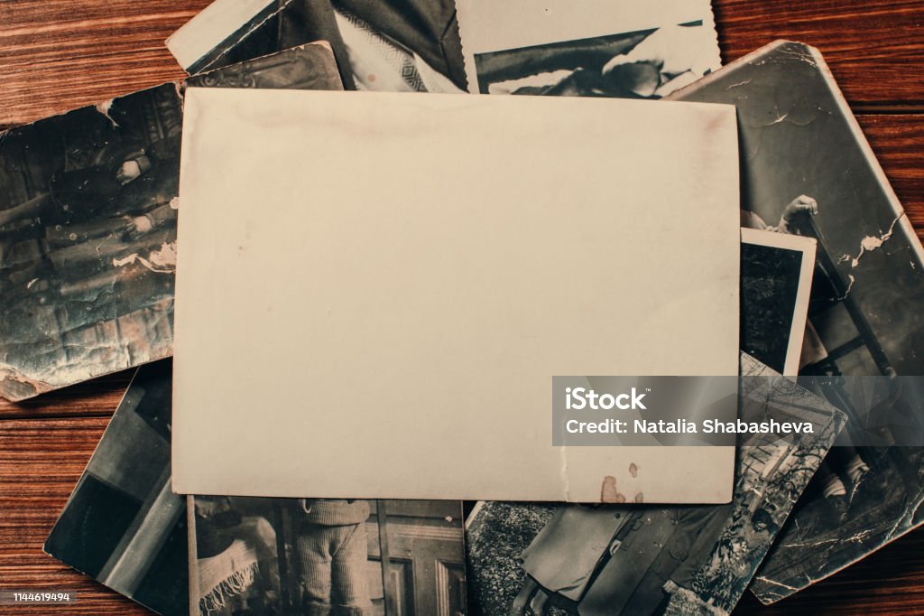 Stack old photos on table. Mock-up blank paper. Postcard rumpled and dirty vintage. Retro card Photograph Stock Photo