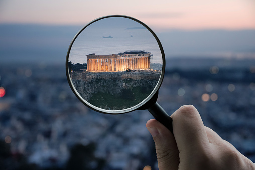 A magnifying glass over the Parthenon building in Athens, Greece