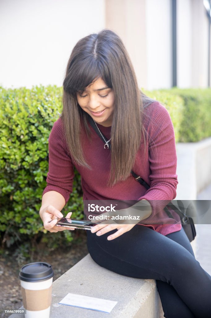 Woman Depositing Checks with Smartphone A Millennial Japanese Woman Depositing Checks with Mobile Check - Financial Item Stock Photo